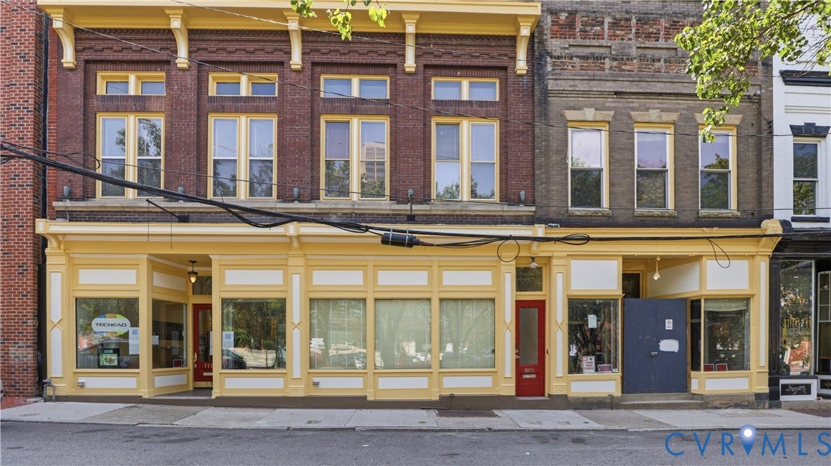 111 N 17th Street, Richmond, VA 23219 Brick facade, office space, ground-level retail spaces, and a red entry door to apartment.