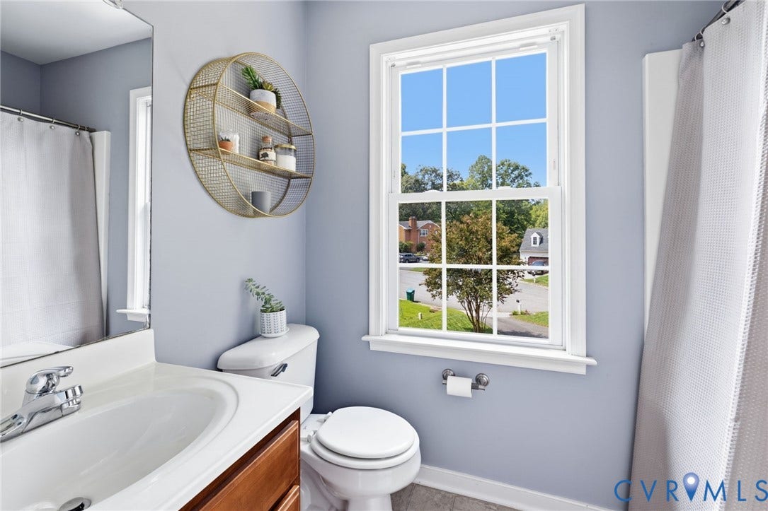 6201 Cameron Bay Terrace, Cameron Bay, Midlothian, VA 23112 White single-hung window with grid, wood-finish vanity with countertop sink, polished chrome faucet, white toilet, and tile flooring