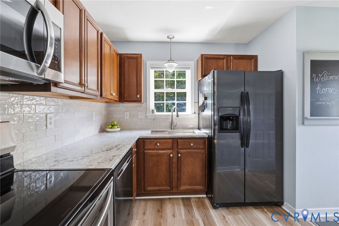 6201 Cameron Bay Terrace, Cameron Bay, Midlothian, VA 23112 Wood-finish flooring, L-shaped countertop, white subway tile backsplash, stainless steel appliances, and wood cabinetry