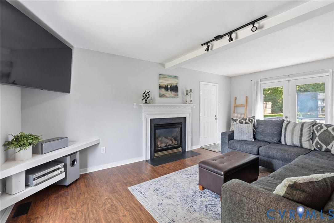 6201 Cameron Bay Terrace, Cameron Bay, Midlothian, VA 23112 Living area featuring wood-finish flooring, a white mantel fireplace with a black hearth, track lighting, and double glass panel doors