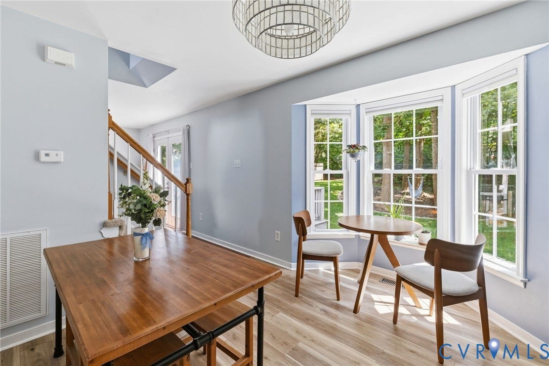 6201 Cameron Bay Terrace, Cameron Bay, Midlothian, VA 23112 Bay window with multiple panes, wood-finish flooring, staircase with wood handrail, light blue wall paint, and a decorative ceiling light fixture