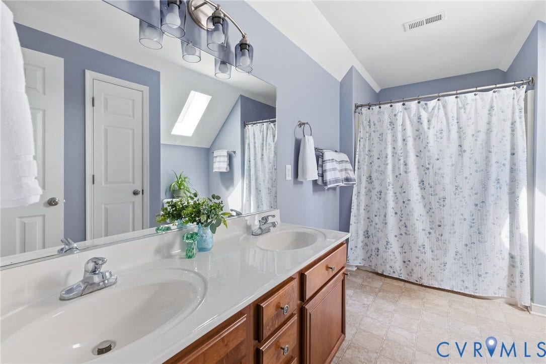 6201 Cameron Bay Terrace, Cameron Bay, Midlothian, VA 23112 Dual vanity with undermount sinks, brown wood-finish cabinetry, and a skylight