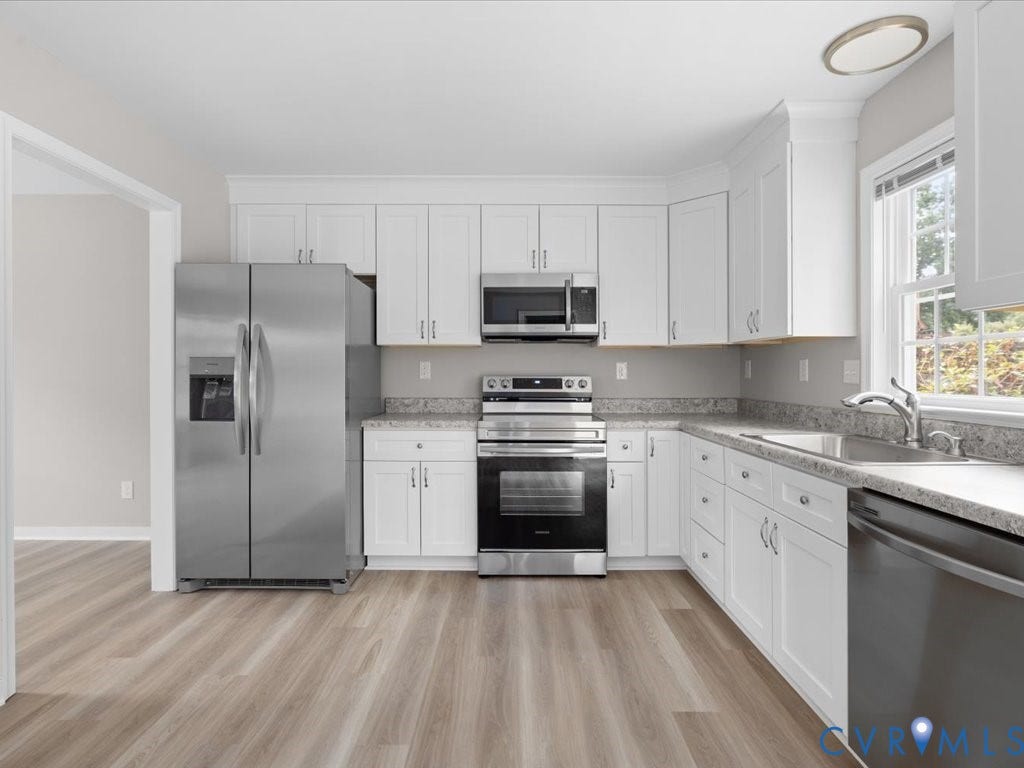 3313 New Found Lane, Chester, VA 23831 Kitchen featuring wood-finish flooring, white cabinetry, stainless steel appliances, and light-toned countertops