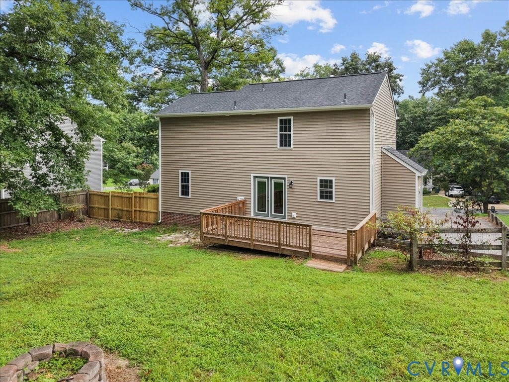 3313 New Found Lane, Chester, VA 23831 Expansive grassy yard featuring a wooden deck with railing, dual pane glass doors, and a partial privacy fence