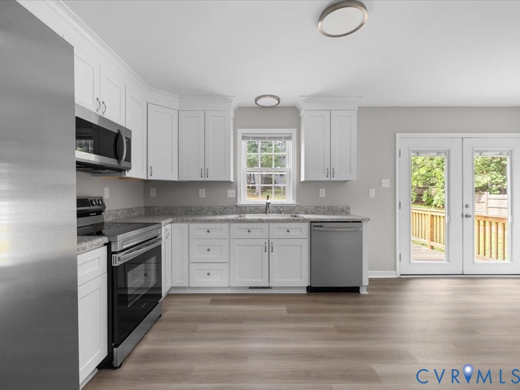 3313 New Found Lane, Chester, VA 23831 Contemporary kitchen featuring white cabinetry, stainless steel appliances, light-toned wood-finish flooring, and a double-door exterior exit