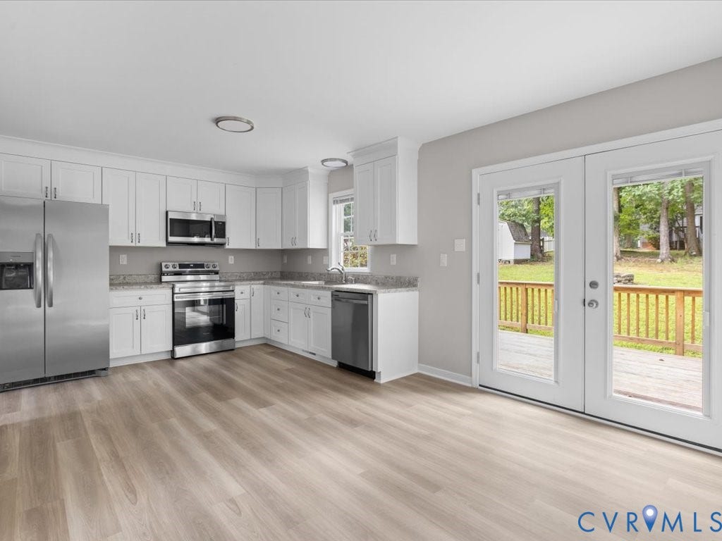 3313 New Found Lane, Chester, VA 23831 Kitchen featuring white cabinetry, stainless steel appliances, light-toned wood-finish flooring, and a glass-paneled double door leading to an outdoor deck