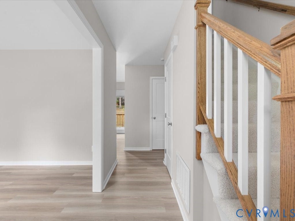 3313 New Found Lane, Chester, VA 23831 Wood-finish flooring throughout, bright white trim, and a carpeted staircase with wood handrails