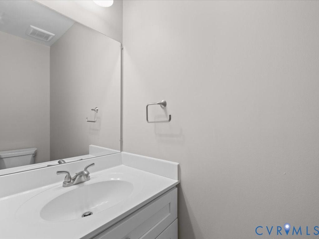 3313 New Found Lane, Chester, VA 23831 White vanity with an integrated sink, brushed nickel faucet, and a large wall-mounted mirror