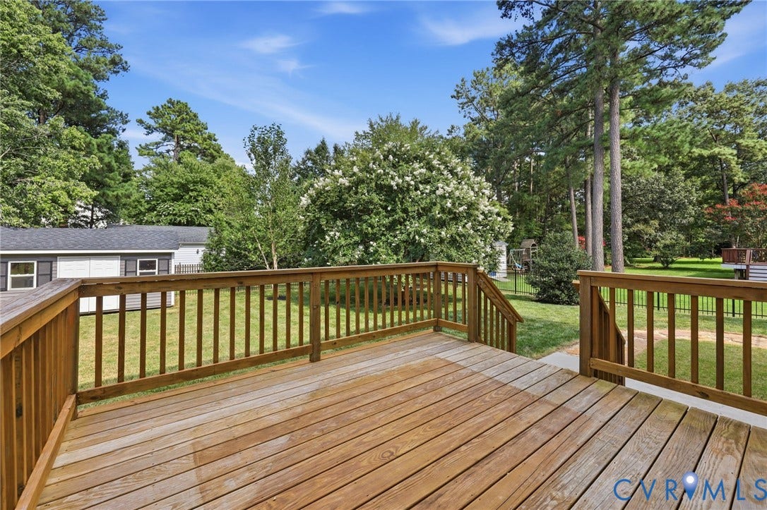 Enjoy outdoor living on the spacious rear deck overlooking the backyard and mature landscaping.