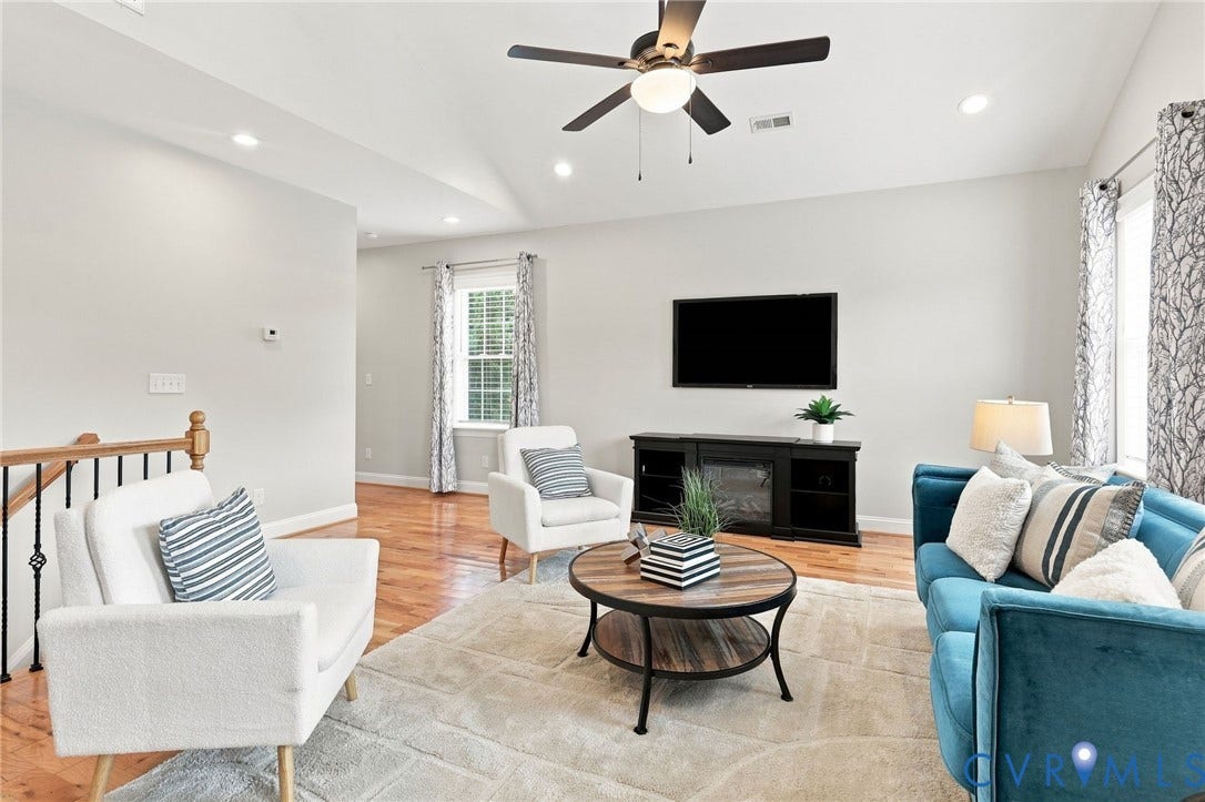 Spacious second-floor loft with vaulted ceiling, hardwood floors, and abundant natural light, perfect for a second living area or media space.