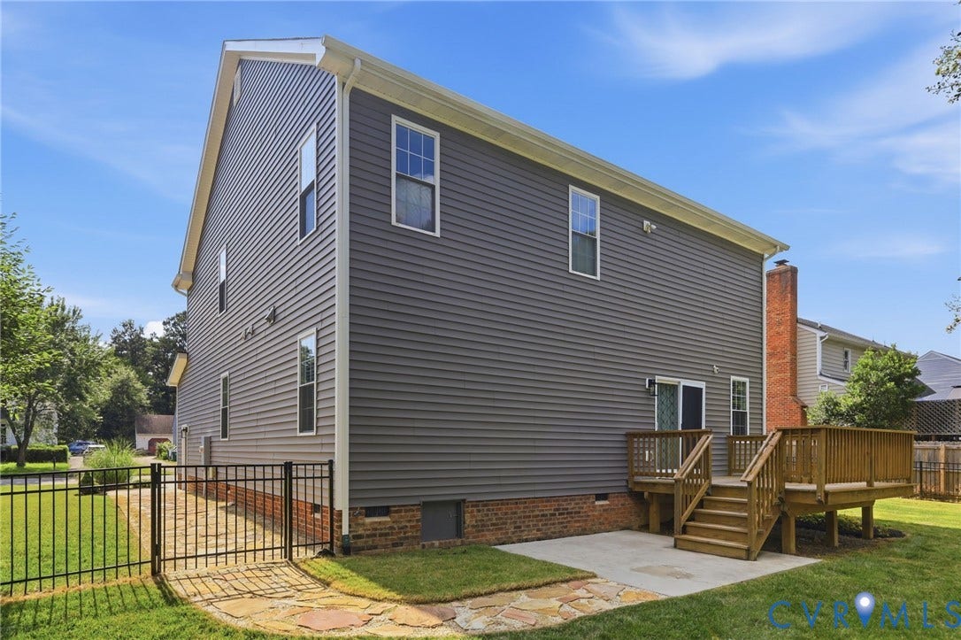 Rear view highlights the deck, patio area, and access to the fully fenced backyard.