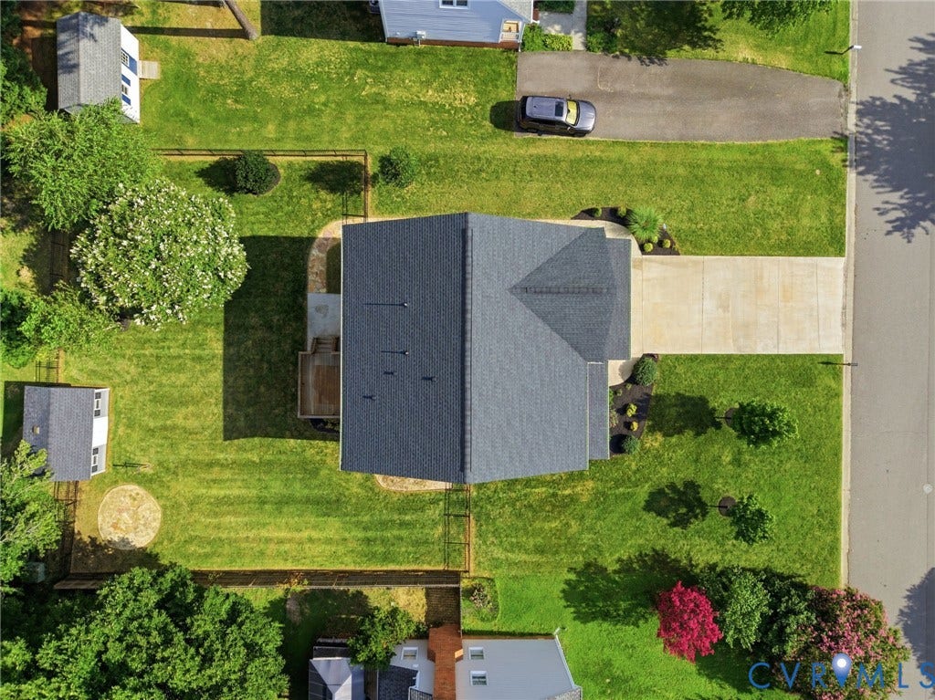 Overhead perspective highlights the propertys spacious lot, fenced backyard, driveway, and overall layout.
