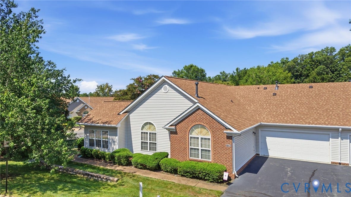 7230 Norwood Pond Court, Midlothian, VA 23112 Property exterior featuring a brick and siding facade, arched window, attached garage, asphalt driveway, and mature landscaping