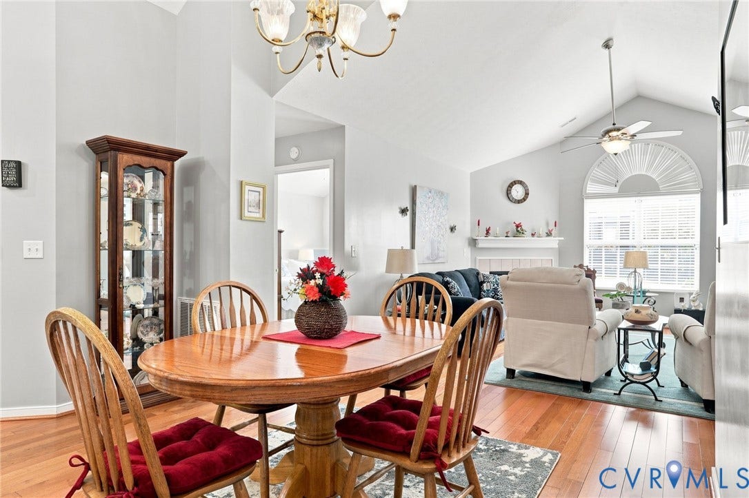 7230 Norwood Pond Court, Midlothian, VA 23112 Hardwood-finish flooring, vaulted ceiling, arched window with horizontal blinds, ceiling fan with integrated lighting, and a fireplace with a mantel