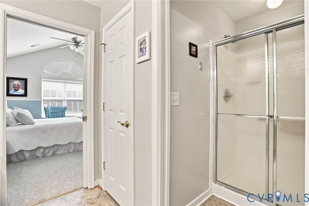 7230 Norwood Pond Court, Midlothian, VA 23112 Glass-enclosed shower with sliding doors, white paneled interior door with brass hardware, and light-toned wall paint