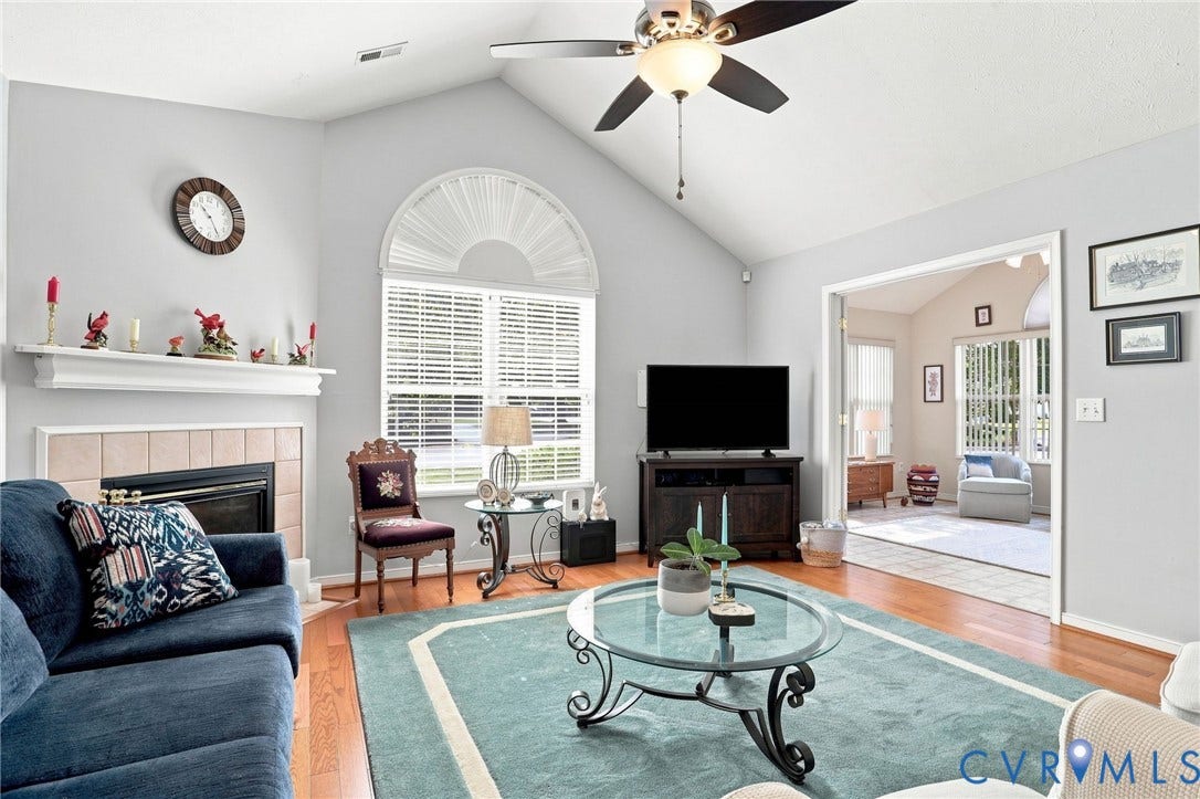 7230 Norwood Pond Court, Midlothian, VA 23112 Vaulted ceiling, hardwood flooring, arched window with blinds, tiled fireplace, and a ceiling fan