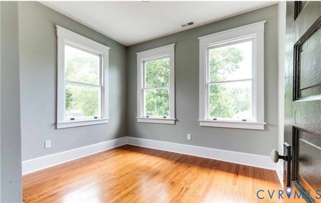 3614 Carolina Avenue, Richmond, VA 23222 Hardwood flooring with a polished finish, multiple windows with white trim, and a paneled door with a spherical knob