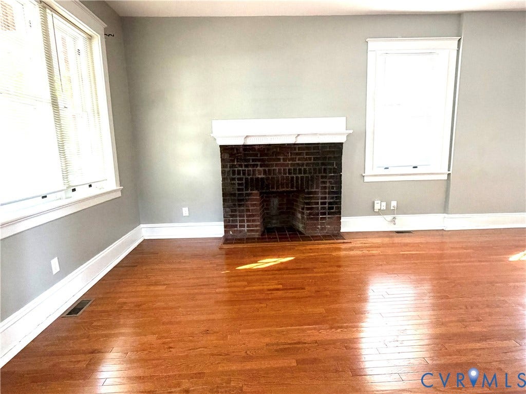 3614 Carolina Avenue, Richmond, VA 23222 Hardwood flooring throughout, brick fireplace with white mantel, and multiple windows