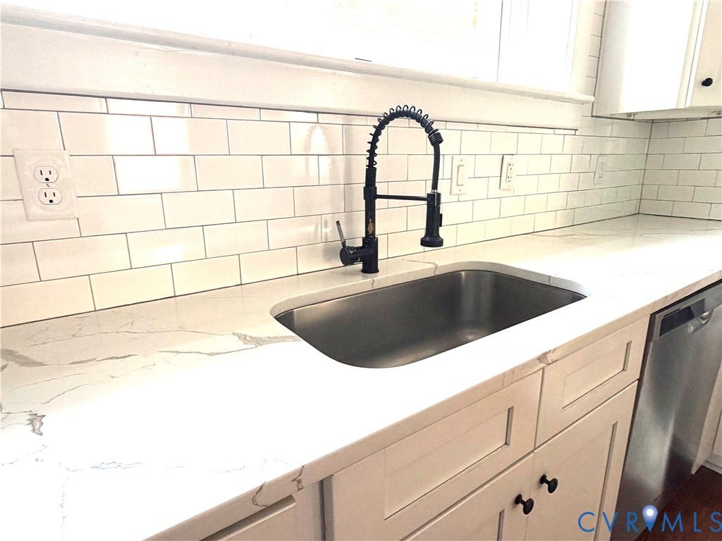3614 Carolina Avenue, Richmond, VA 23222 Undermount stainless steel sink with a matte black high-arc faucet, quartz countertops, white subway tile backsplash, and white shaker-style cabinetry