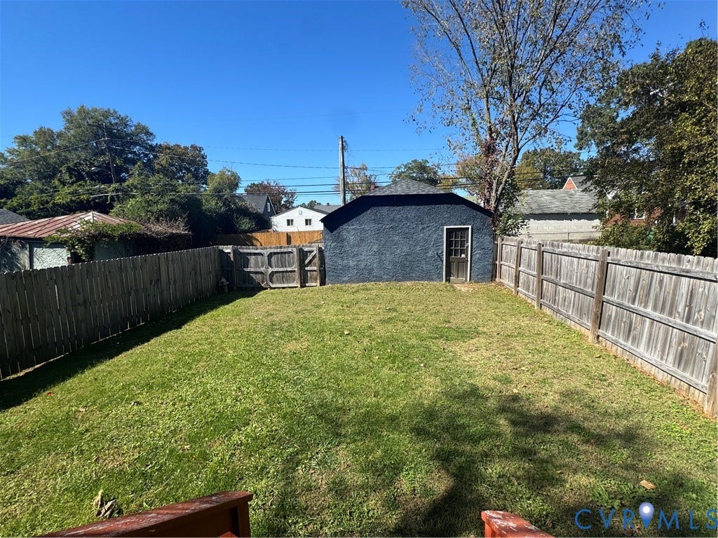 3614 Carolina Avenue, Richmond, VA 23222 Expansive backyard featuring a privacy fence, a detached structure with stucco siding, and a wooden gate