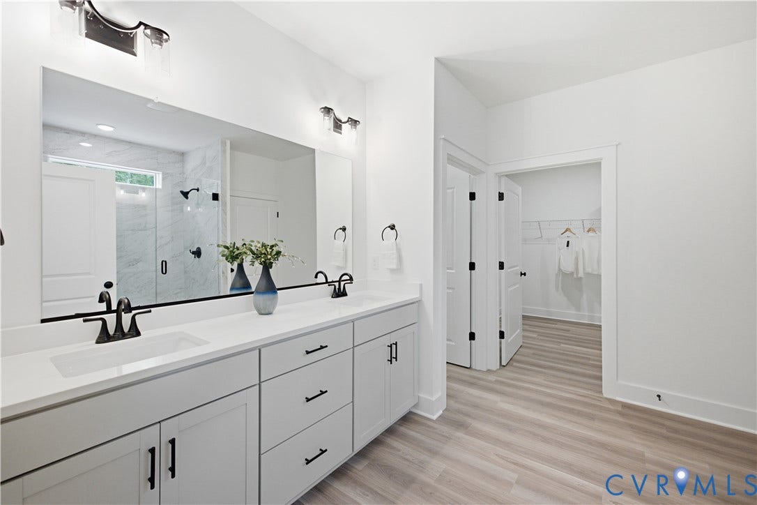 Private water closet on the left, views to primary walk-in-closet. Photos of the for-sale home, staged.