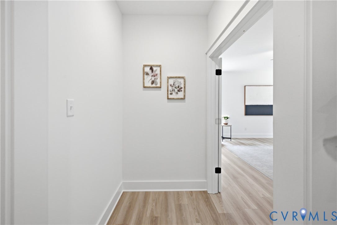 Vestibule to primary bedroom from family room. Photos of the for-sale home, staged.