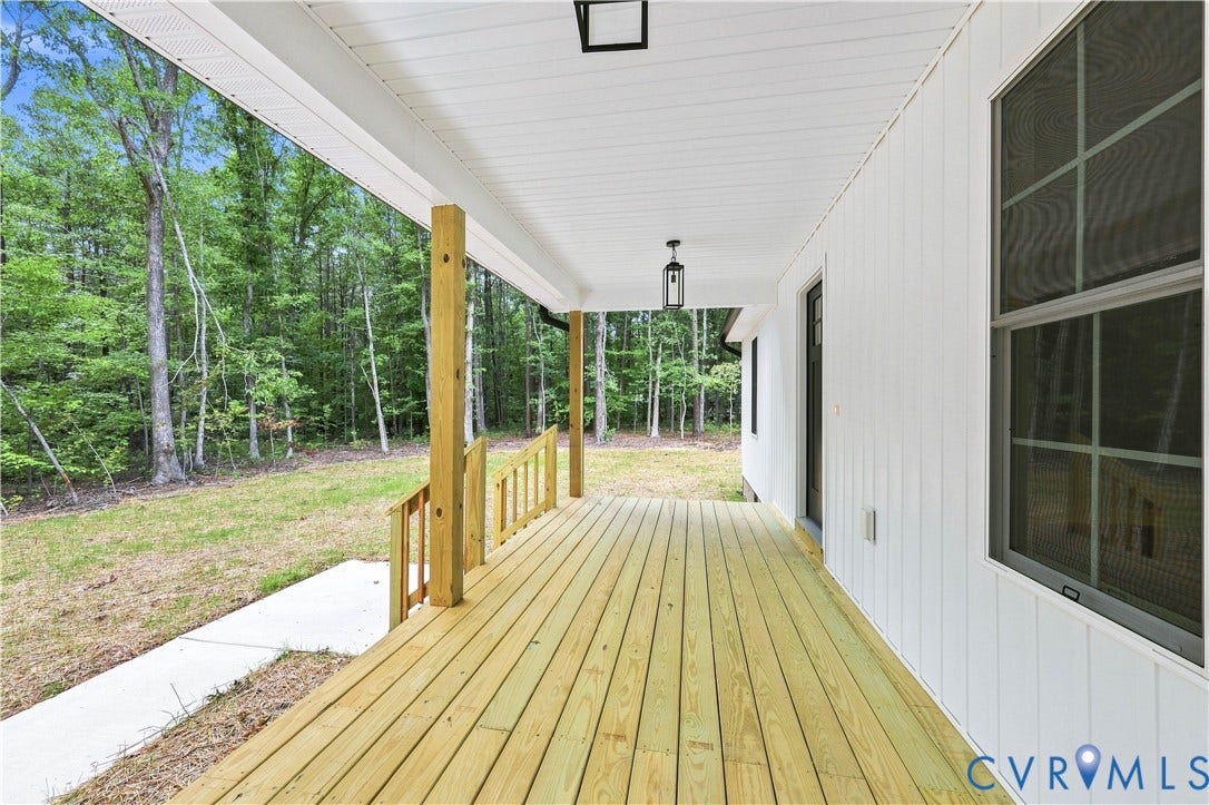 42 Clinton Farm Court, Clinton Farm, Cumberland, VA 23040 Expansive covered front porch with a wood deck, wood support posts, and black exterior lighting fixtures