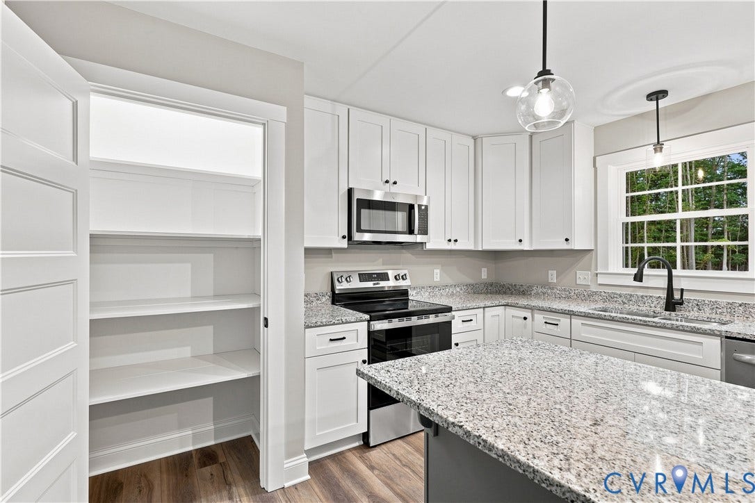 42 Clinton Farm Court, Clinton Farm, Cumberland, VA 23040 Kitchen featuring a central island, white cabinetry, granite countertops, and stainless steel appliances