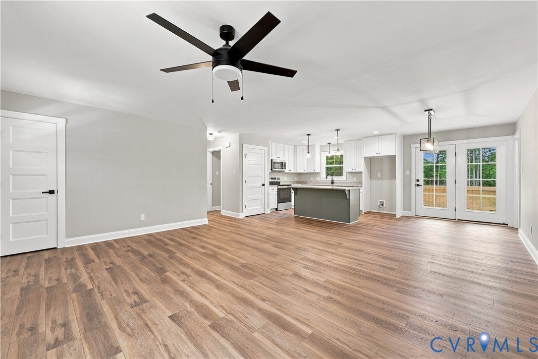 42 Clinton Farm Court, Clinton Farm, Cumberland, VA 23040 Open-concept living area featuring wood-finish flooring, a modern ceiling fan, and white kitchen cabinetry