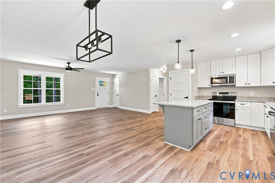 42 Clinton Farm Court, Clinton Farm, Cumberland, VA 23040 Wood-finish flooring, white cabinetry, stainless steel appliances, central kitchen island with seating, and recessed lighting