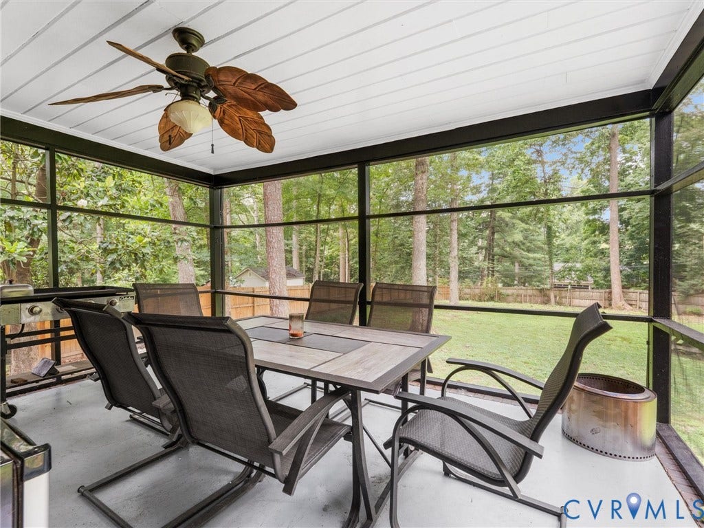 Screened-in porch featuring a ceiling fan with light, white paneled ceiling, and a concrete floor