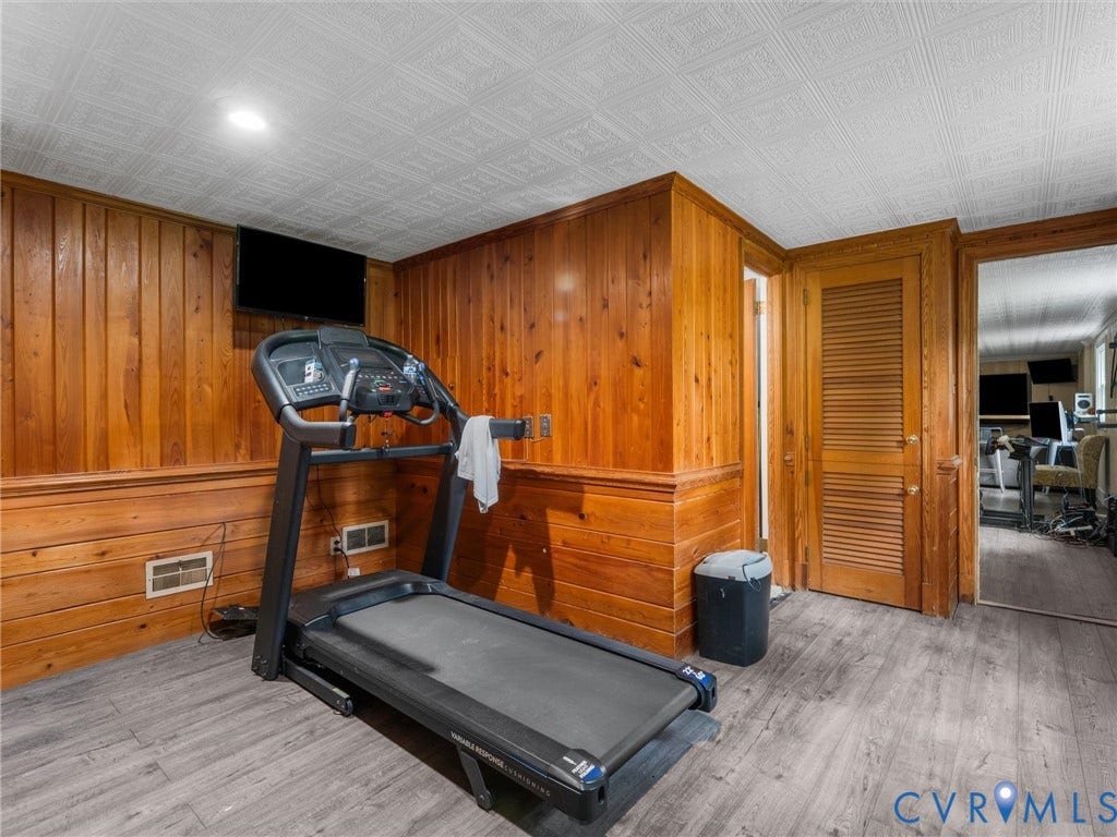 Wood paneling, wood-finish flooring, recessed lighting, wood louvered door, wood trim