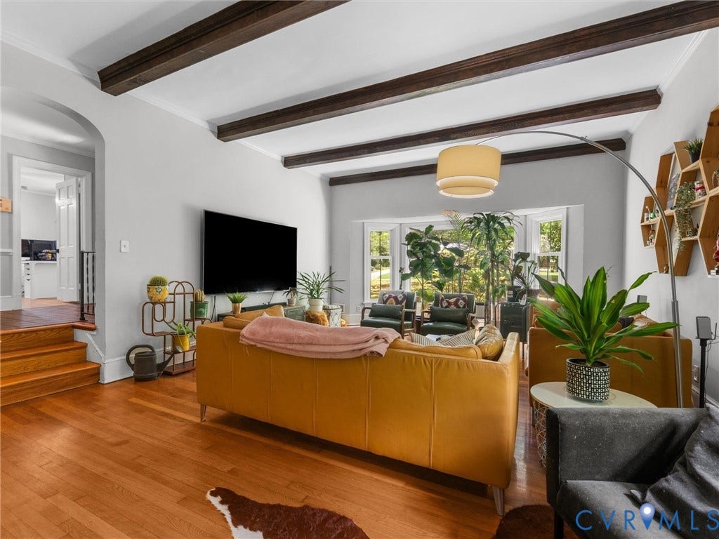 Wood-finish flooring throughout, complemented by exposed ceiling beams and a bay window