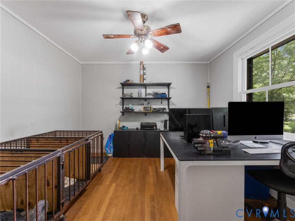 Wood-finish flooring, white trim, and a ceiling fan with light fixture