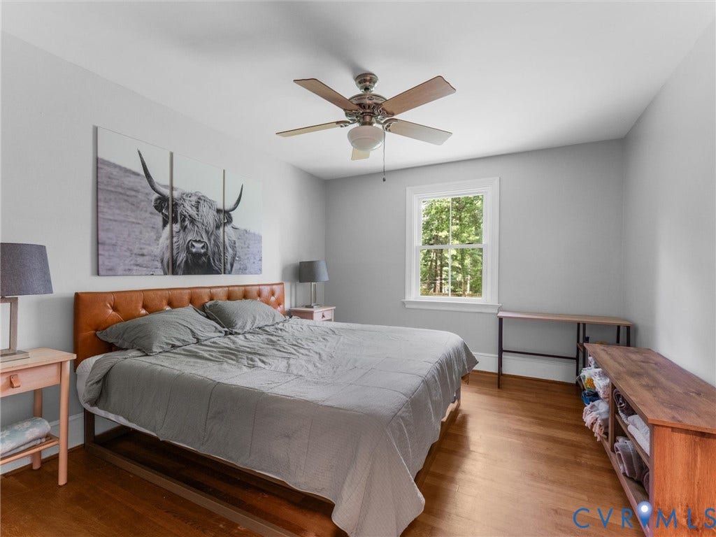 Hardwood flooring, painted walls, ceiling fan, and a window with white trim