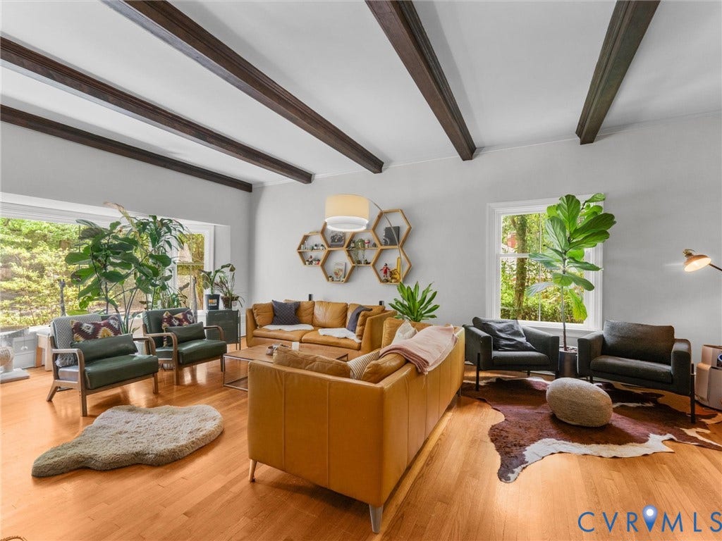 Hardwood flooring, exposed ceiling beams, large window, and built-in shelving
