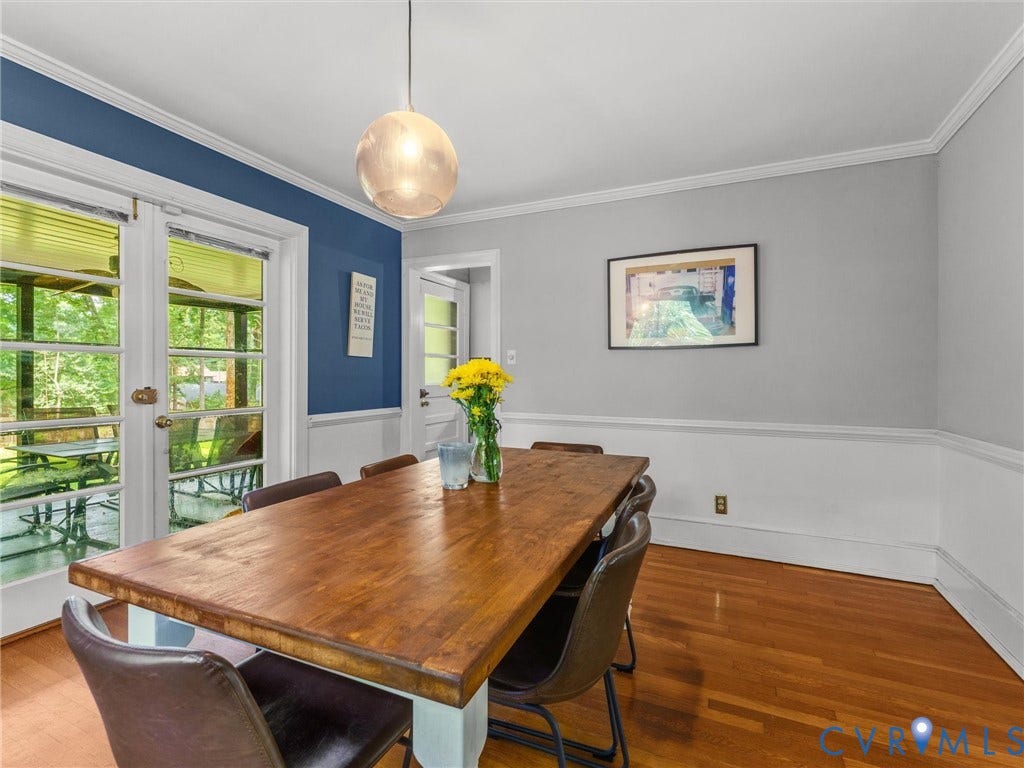 Hardwood flooring, crown molding, white trim, recessed panel wainscoting, and French doors leading to an outdoor area