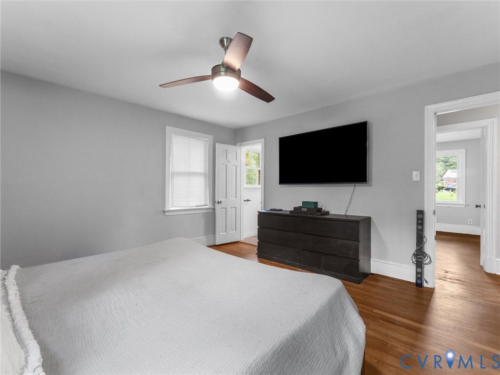 Hardwood flooring, ceiling fan with integrated lighting, white trim and baseboards, light gray wall paint, and white paneled doors