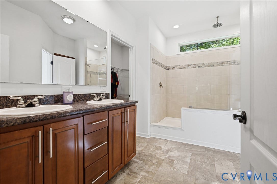 2575 Log Cabin Road, Maidens, VA 23102 En Suite Primary Bath feautring a dual vanity with brown cabinetry and light-colored countertops, Walk in closet and private water closet.