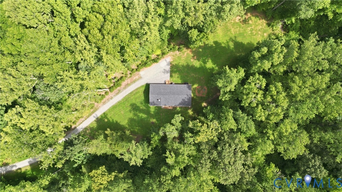 2575 Log Cabin Road, Maidens, VA 23102 Wooded setting with a gravel driveway leading to a single-story residence featuring a dark shingled roof