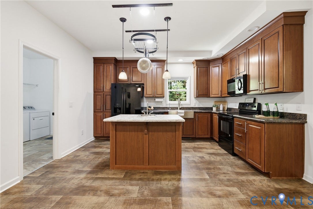 2575 Log Cabin Road, Maidens, VA 23102 Kitchen featuring wood-finish flooring, a central island, wood cabinetry, dark countertops, and black appliances
