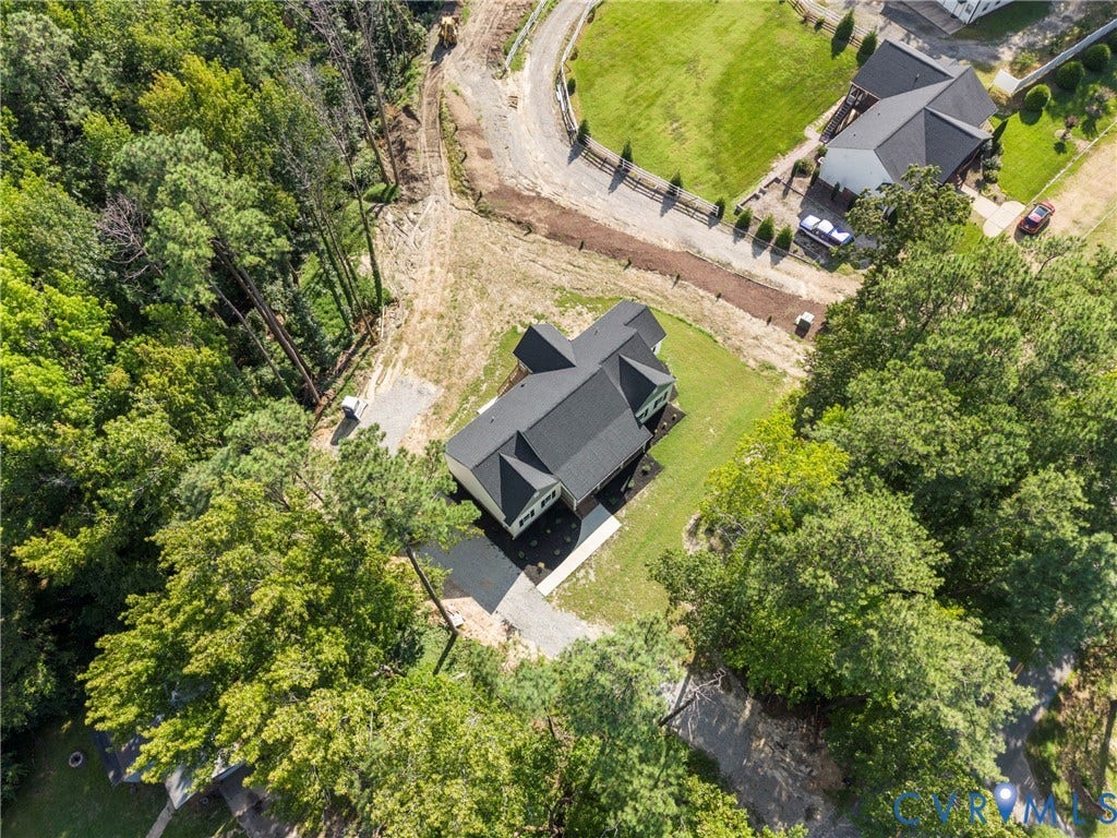New construction residence with dark shingle roofing, light-colored siding