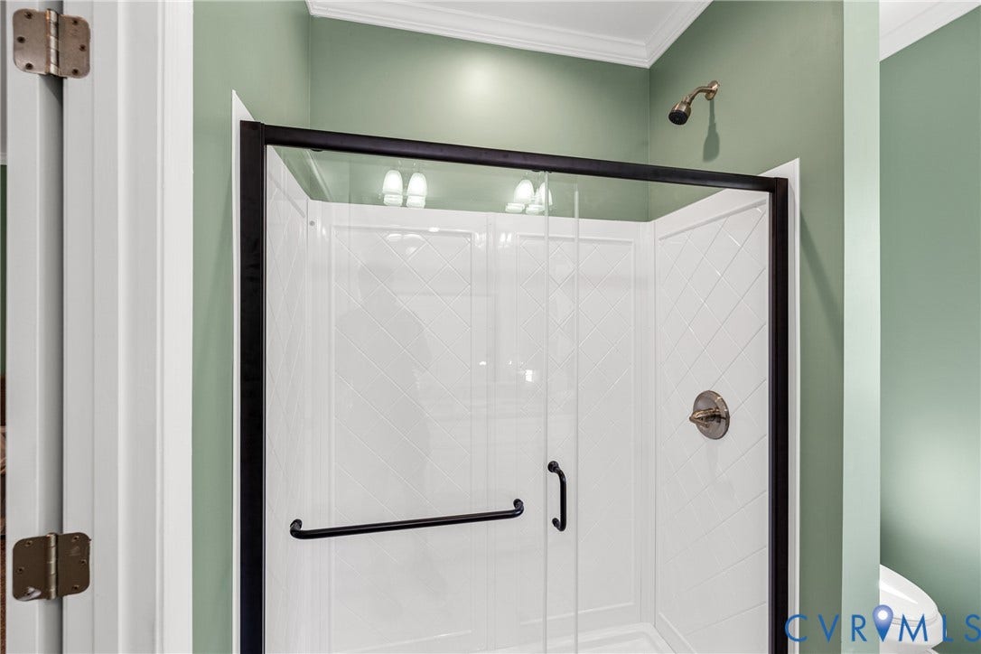 Shower enclosure with black-framed glass doors, white patterned interior walls