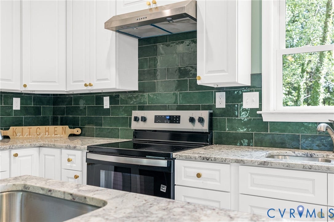 White cabinetry with grantie countertops, stainless steel range with overhead vent, and a green subway tile backsplash