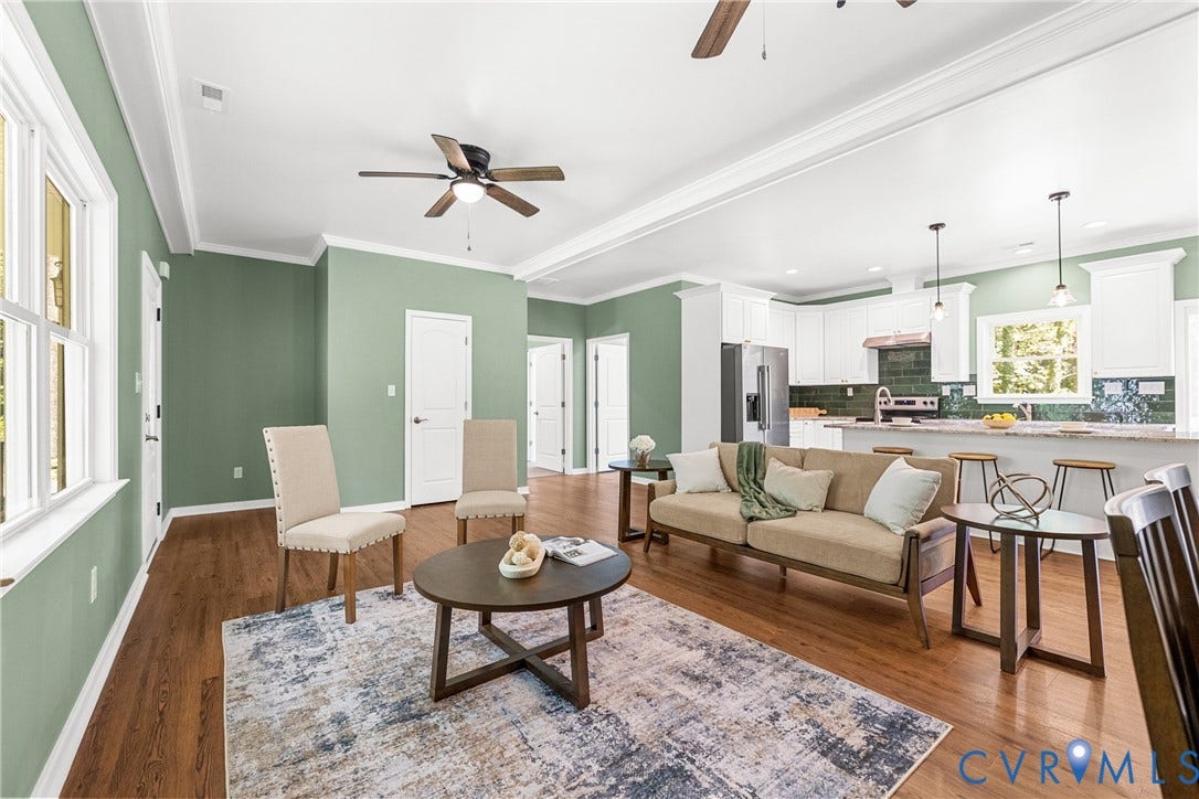 Open-concept living space featuring laminate flooring, white crown molding, a ceiling fan, and recessed lighting