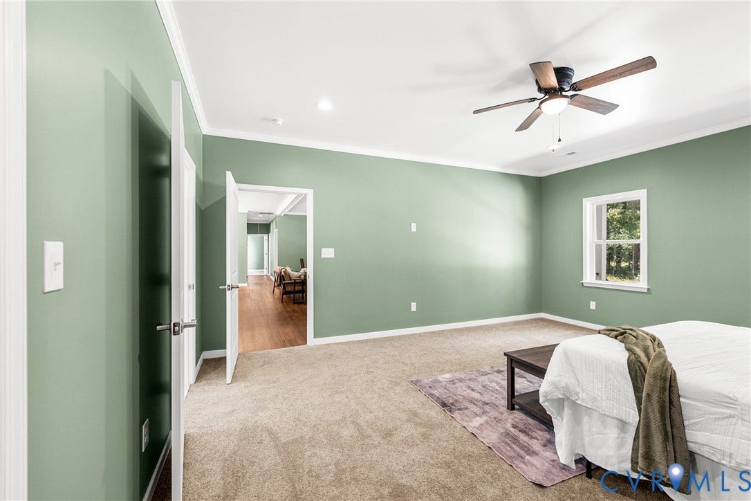 Spacious room featuring neutral carpeting, a ceiling fan with integrated lighting, and a double-hung window