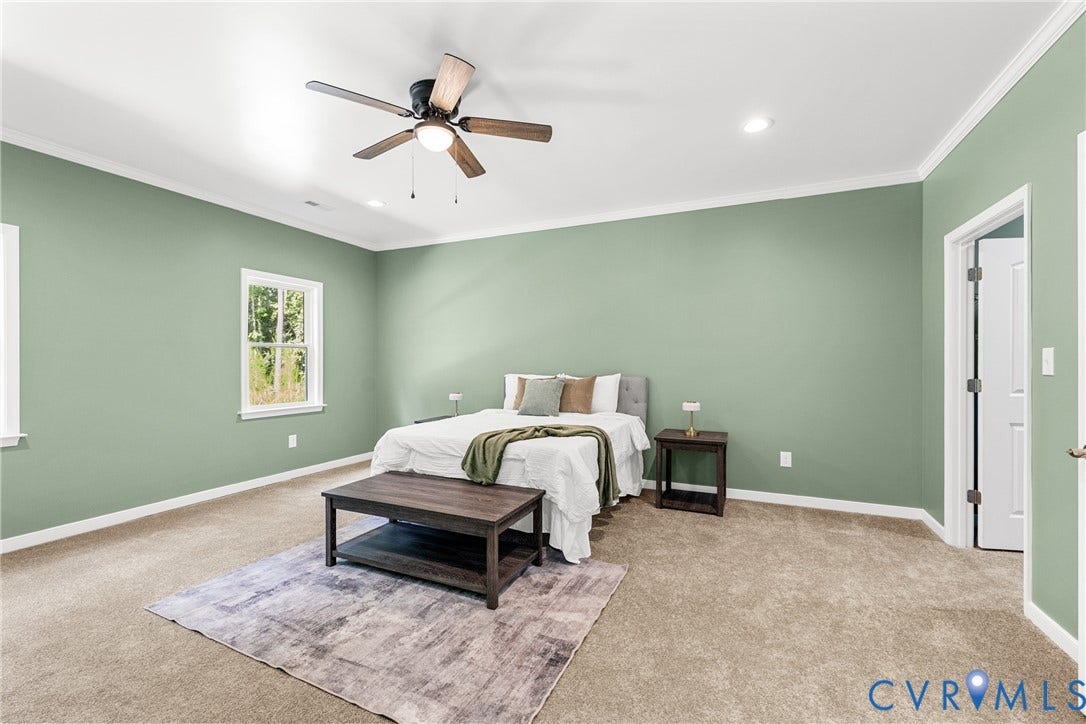 Recessed lighting, ceiling fan with wood-finish blades, and neutral carpeting