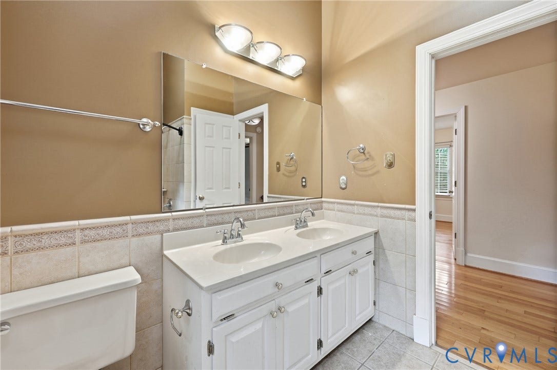 505 Martineau Drive, Chesterfield, VA 23836 Dual vanity with white cabinetry, integrated sinks, chrome fixtures, and a large wall-mounted mirror