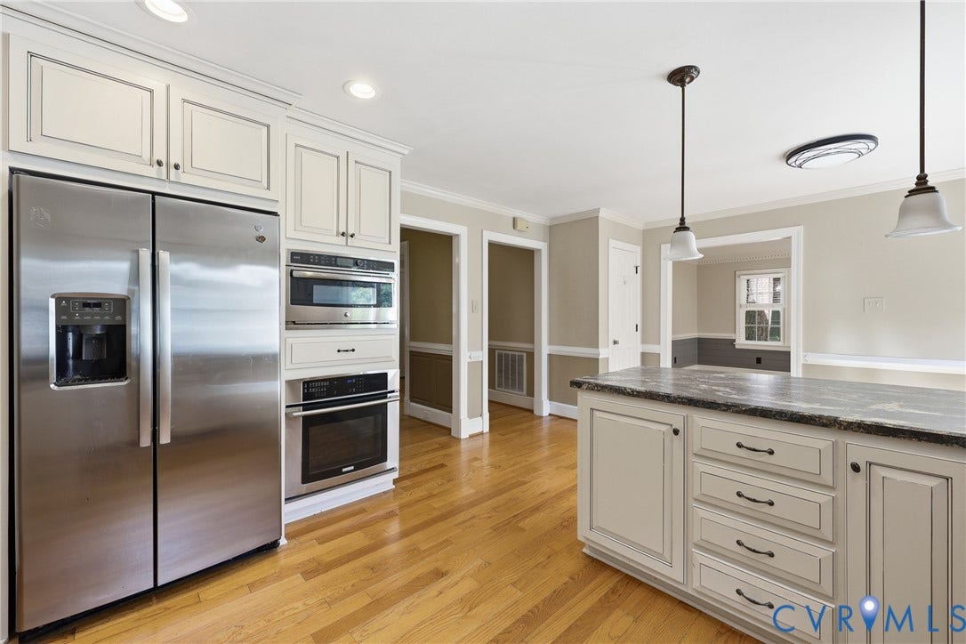 505 Martineau Drive, Chesterfield, VA 23836 Kitchen featuring wood-finish flooring, stainless steel appliances, upper and lower cabinetry, and a center island with a stone countertop