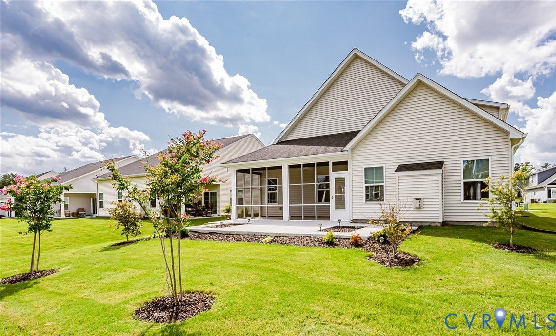 7683 Autumn Leaves Lane, Estates The Groves At New Kent, New Kent, VA 23124 Expansive backyard featuring a screened-in porch, concrete patio, sloped lawn, and planted trees